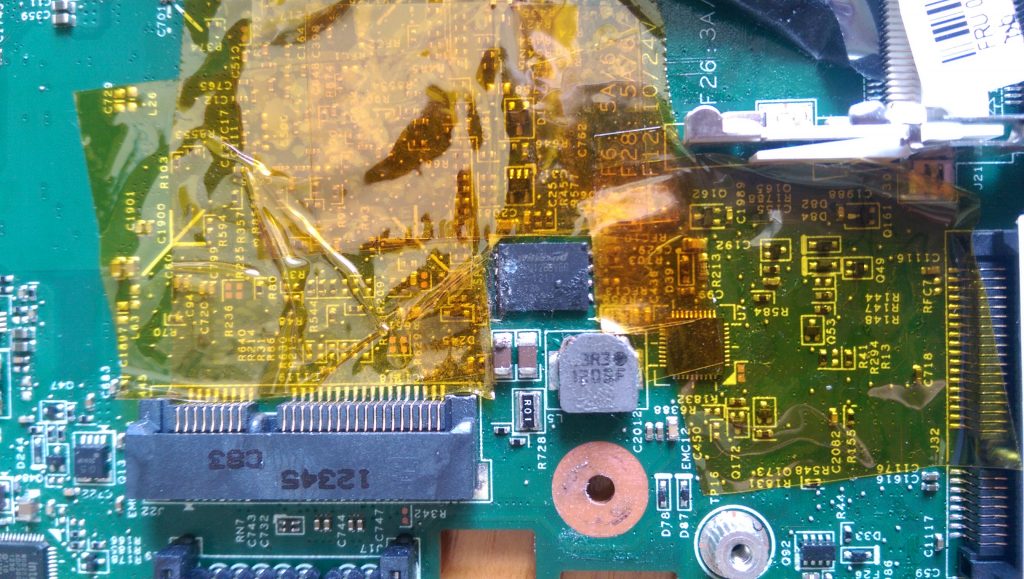 Board covered in Kapton tape &ndash; notice the dodgy solder balls around the chip